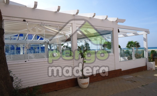 Cortinas de cristal en pérgola de madera blanca